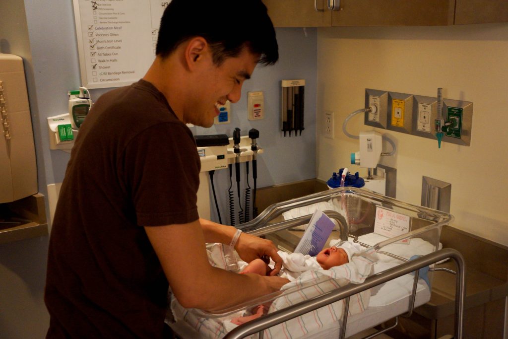 Parent changeant la couche de son bébé, indispensable du sac à langer