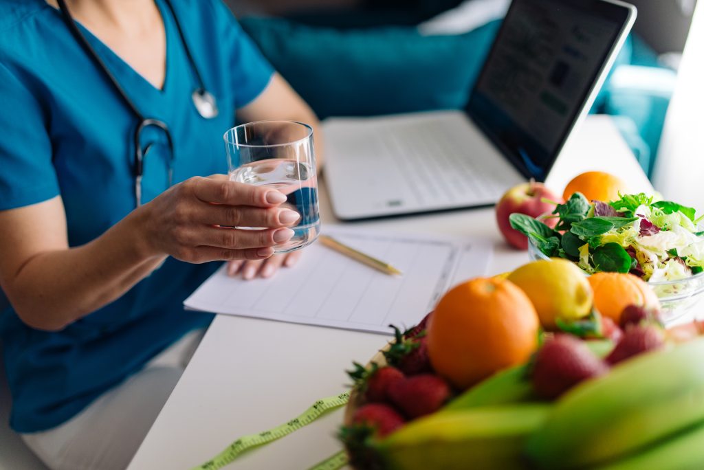 Verre d eau et fruits et legumes frais pour favoriser la circulation et limiter les jambes lourdes