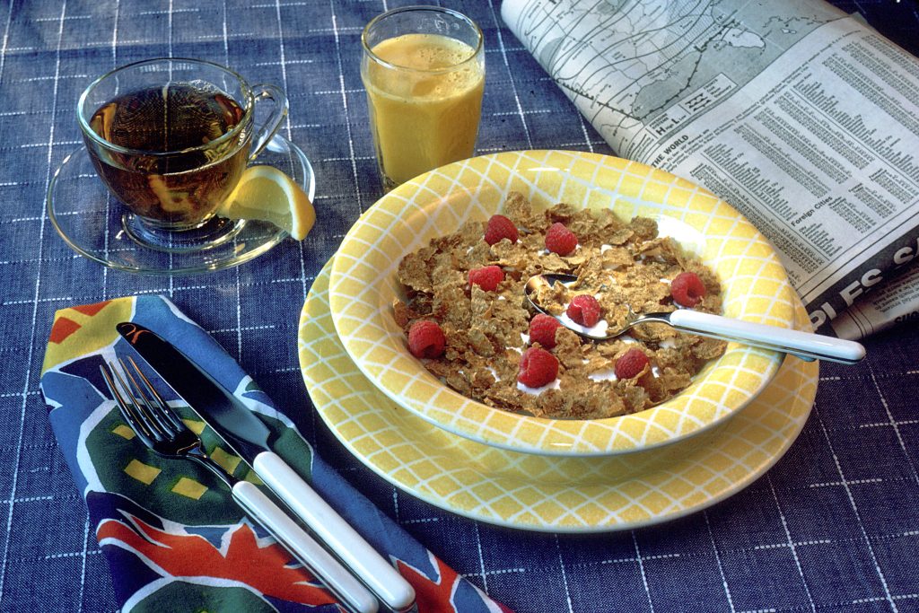 Verre de jus d’orange frais et petit-déjeuner servi sur une table de brunch