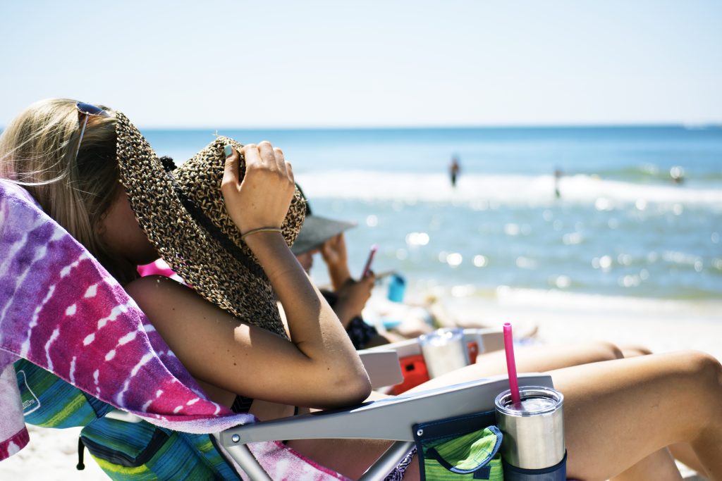 Femme au teint h&acirc;l&eacute; profitant de l'&eacute;t&eacute; au bord de la mer