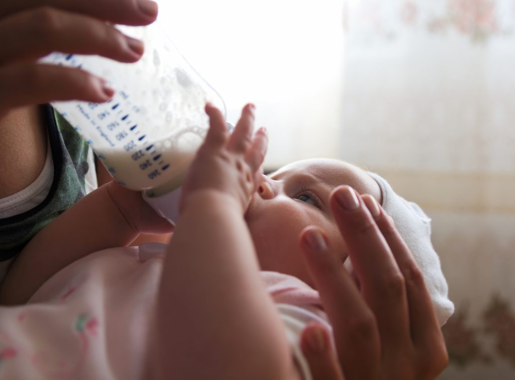 Bébé buvant un biberon pour rester bien hydraté en été