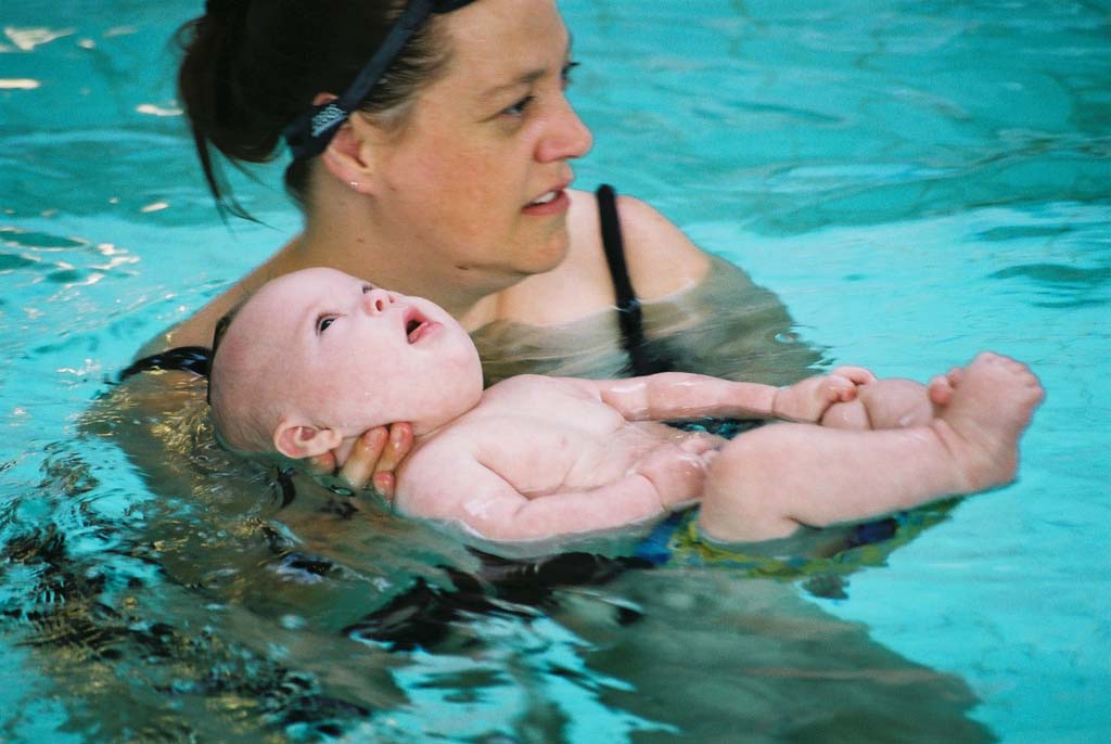Parent accompagnant un jeune enfant lors d'une leçon de natation en piscine