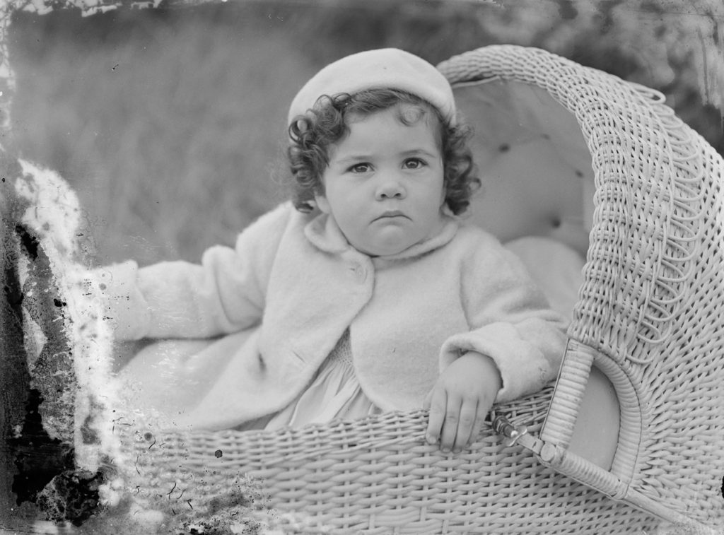 Bébé installé dans un landau protégé lors d'une promenade en extérieur