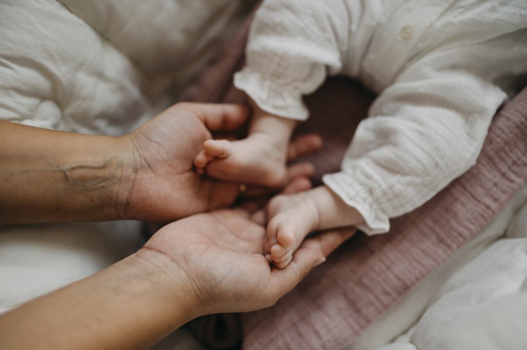 Main d'un parent tenant celle de son bébé, symbole de soin et d'attention